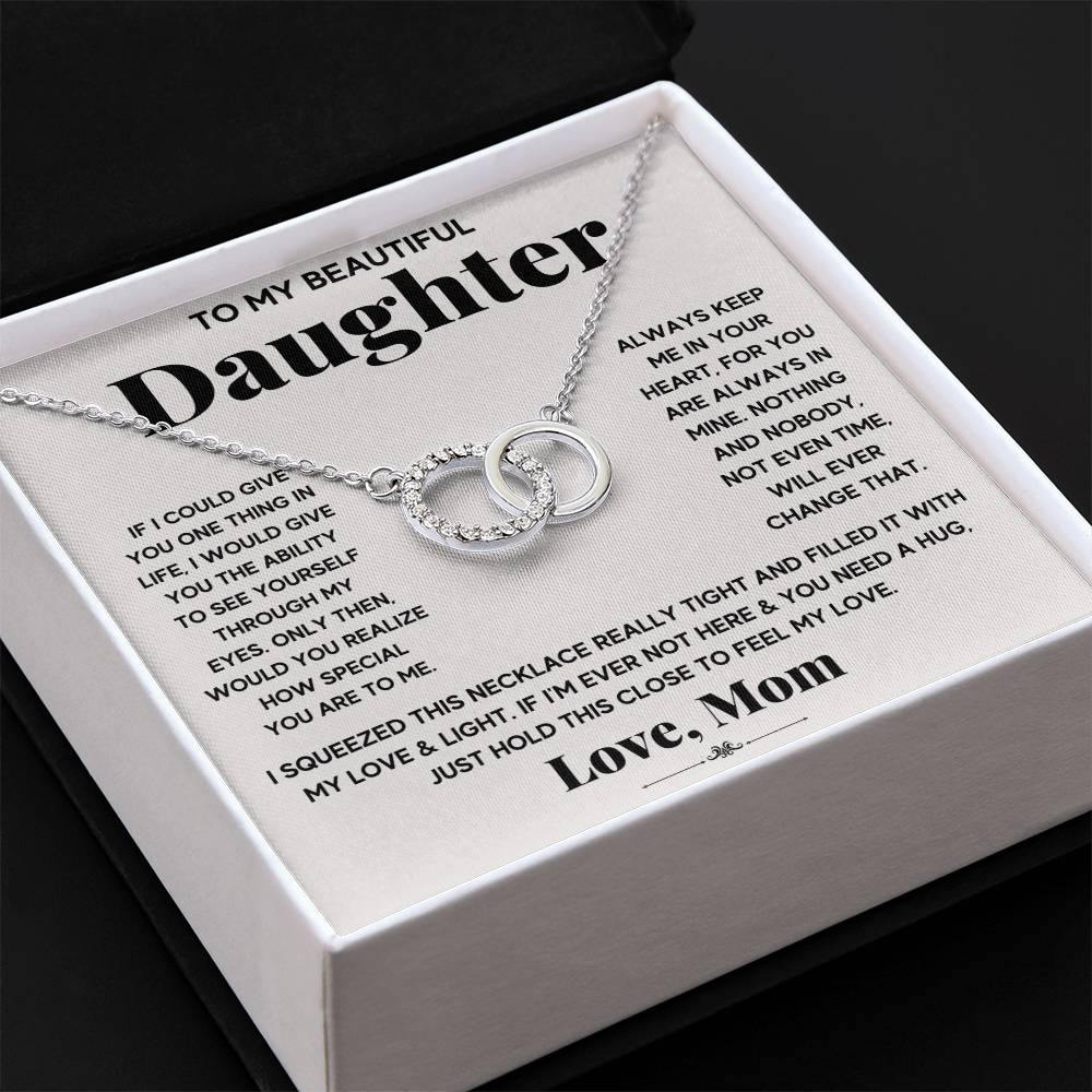 picture if of a card with a necklace on it with two interlocking circles on it