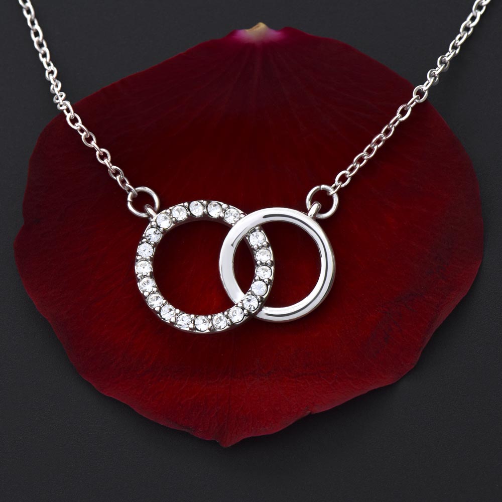 picture if of a card with a necklace on it with two interlocking circles on it