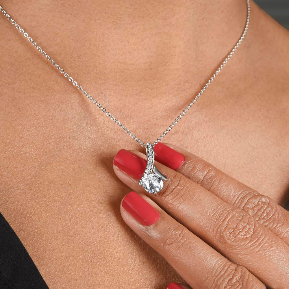 Woman wearing a necklace featuring a 7mm cubic zirconia pendant in 14k white gold finish over stainless steel, pendant dimensions 0.8 inches in height and 0.4 inches in width, adjustable chain length of 18 to 22 inches, with a lobster clasp.
