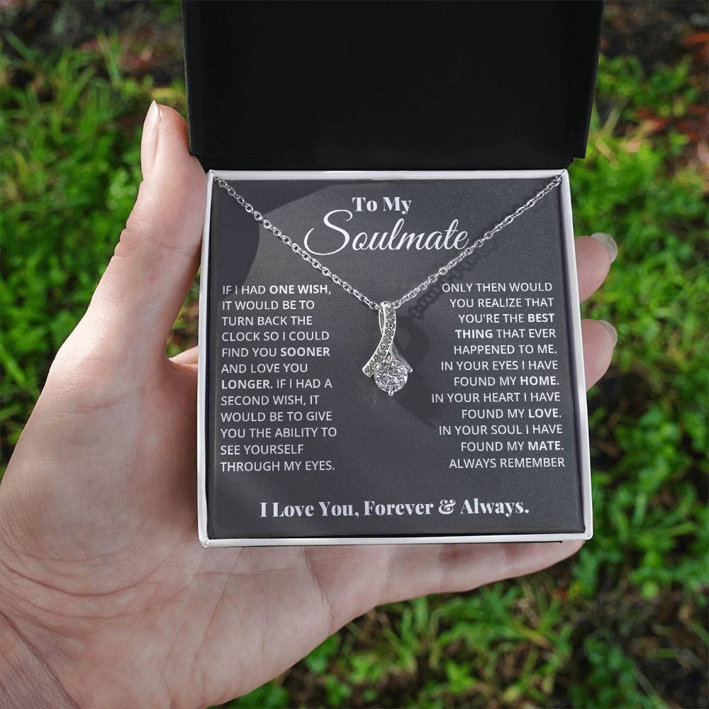 Jewelry card gift with a necklace on it, the necklace is a single pendant with a large cubit zirconia suspended by a curved bar with smaller cubit zirconia
