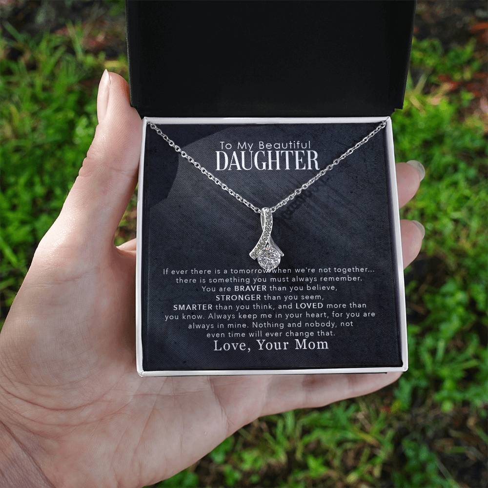 jewelry card with a necklace on it the necklace has a large cubit zirconia in the middle and is suspended on a lpiece of metal with numerous small cubity zirocnia on it