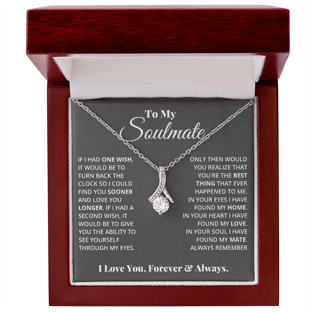 Jewelry card gift with a necklace on it, the necklace is a single pendant with a large cubit zirconia suspended by a curved bar with smaller cubit zirconia