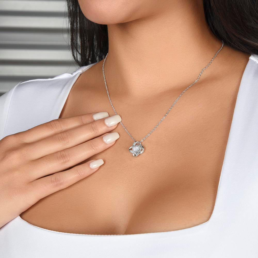 Woman wearing a 14k white gold over stainless steel love knot pendant neckalce