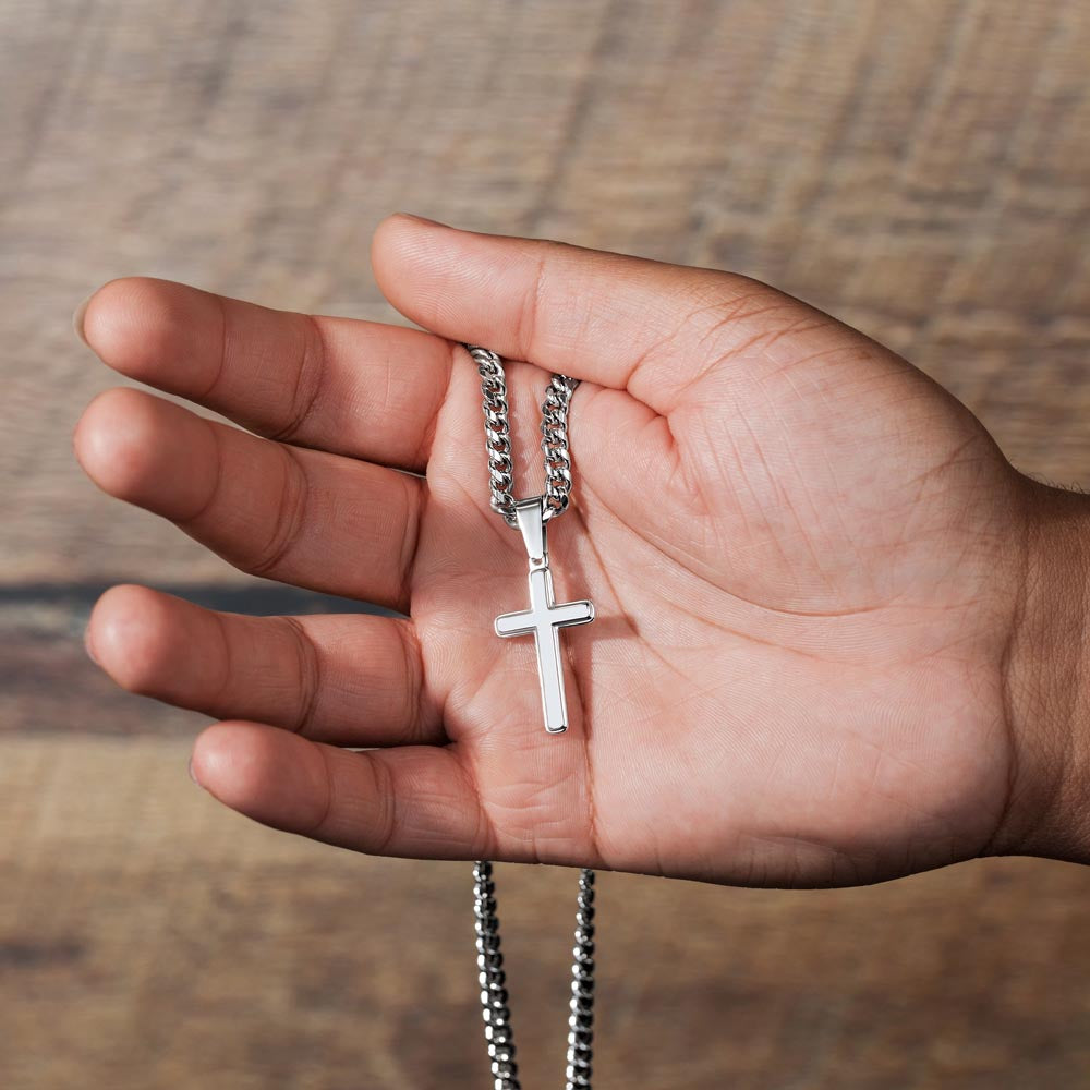 Photograph of a man's hand holding a Heavy Cuban link chain with a cross for a man necklace