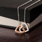 Necklace featuring two heart pendants adorned with CZ crystals, available in polished surgical steel with a rose gold or 18k yellow gold finish, adjustable from 18 to 22 inches.