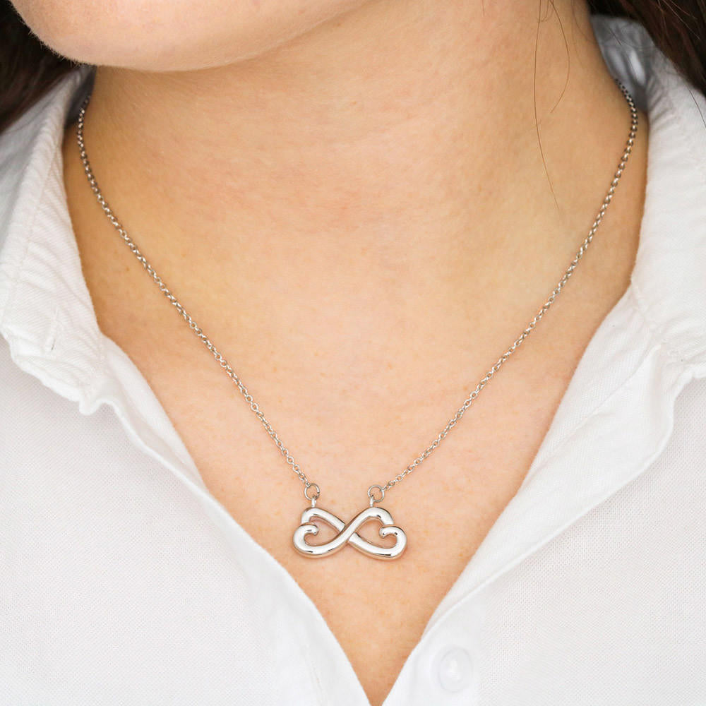 Woman wearing an Endless Love Necklace, showcasing a heart-shaped infinity symbol in 14k white gold or 18k yellow gold finish, polished to perfection, adjustable chain."
